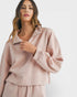 Woman wearing a light pink outfit on a white background