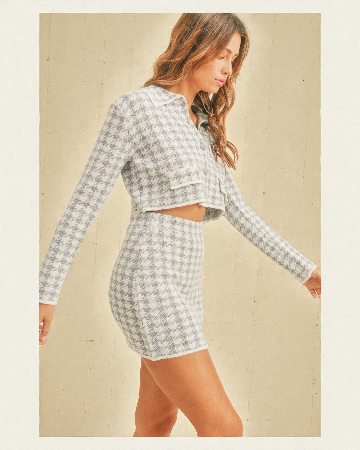 Woman wearing a houndstooth patterned outfit on a beige background