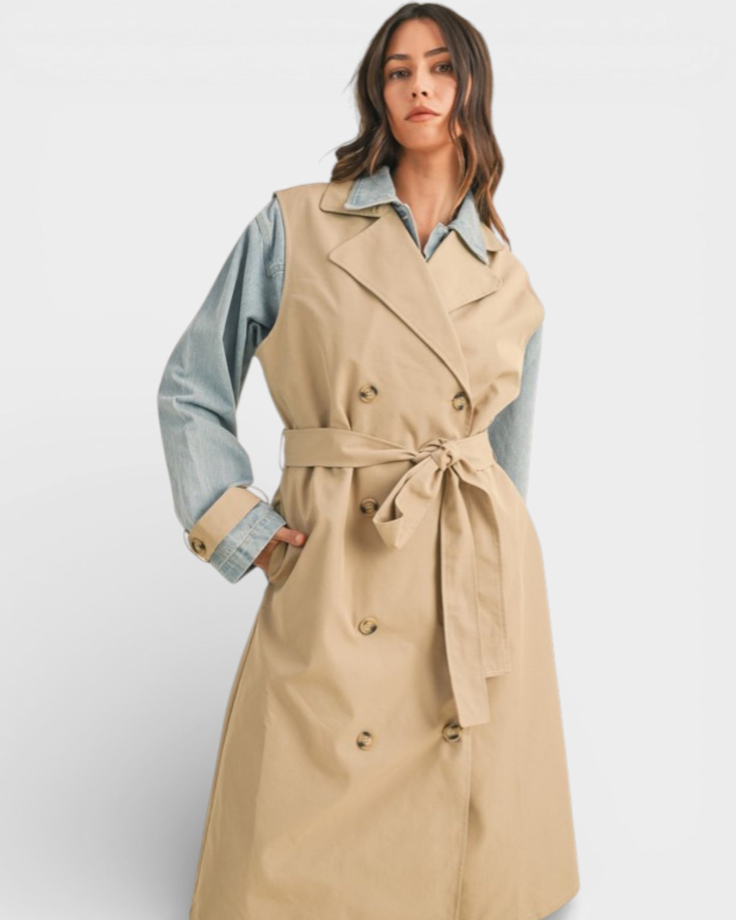 Woman wearing a beige trench coat with a white background