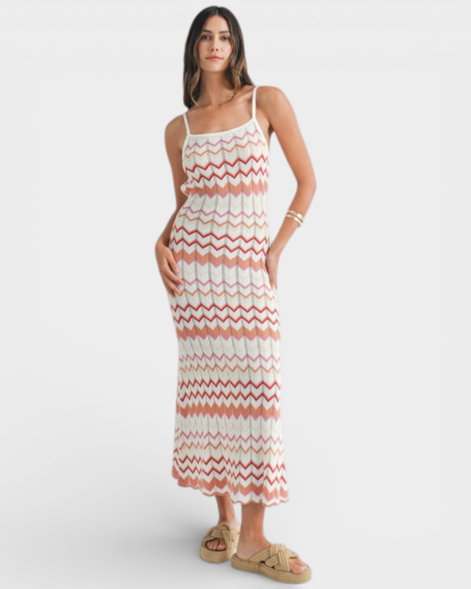 Woman wearing a long, patterned dress on a white background