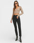 Woman wearing a beige long-sleeve top and black jeans on a white background