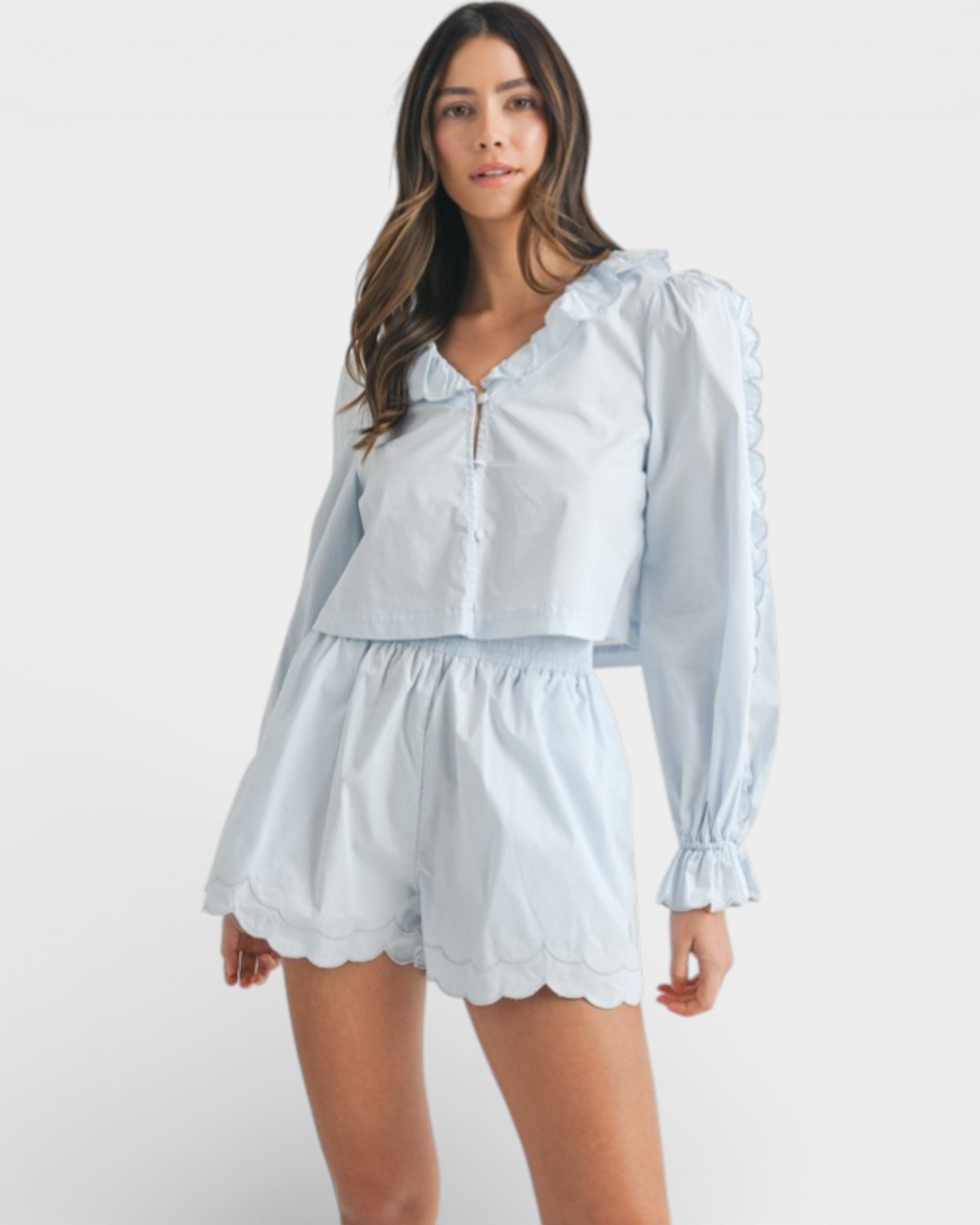 Woman wearing a light blue outfit with a matching top and shorts on a white background