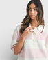 Woman wearing a pastel striped shirt against a white background