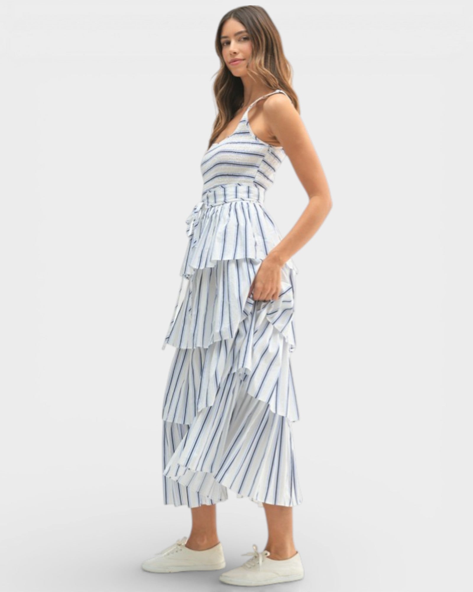Woman wearing a tiered striped dress on a white background