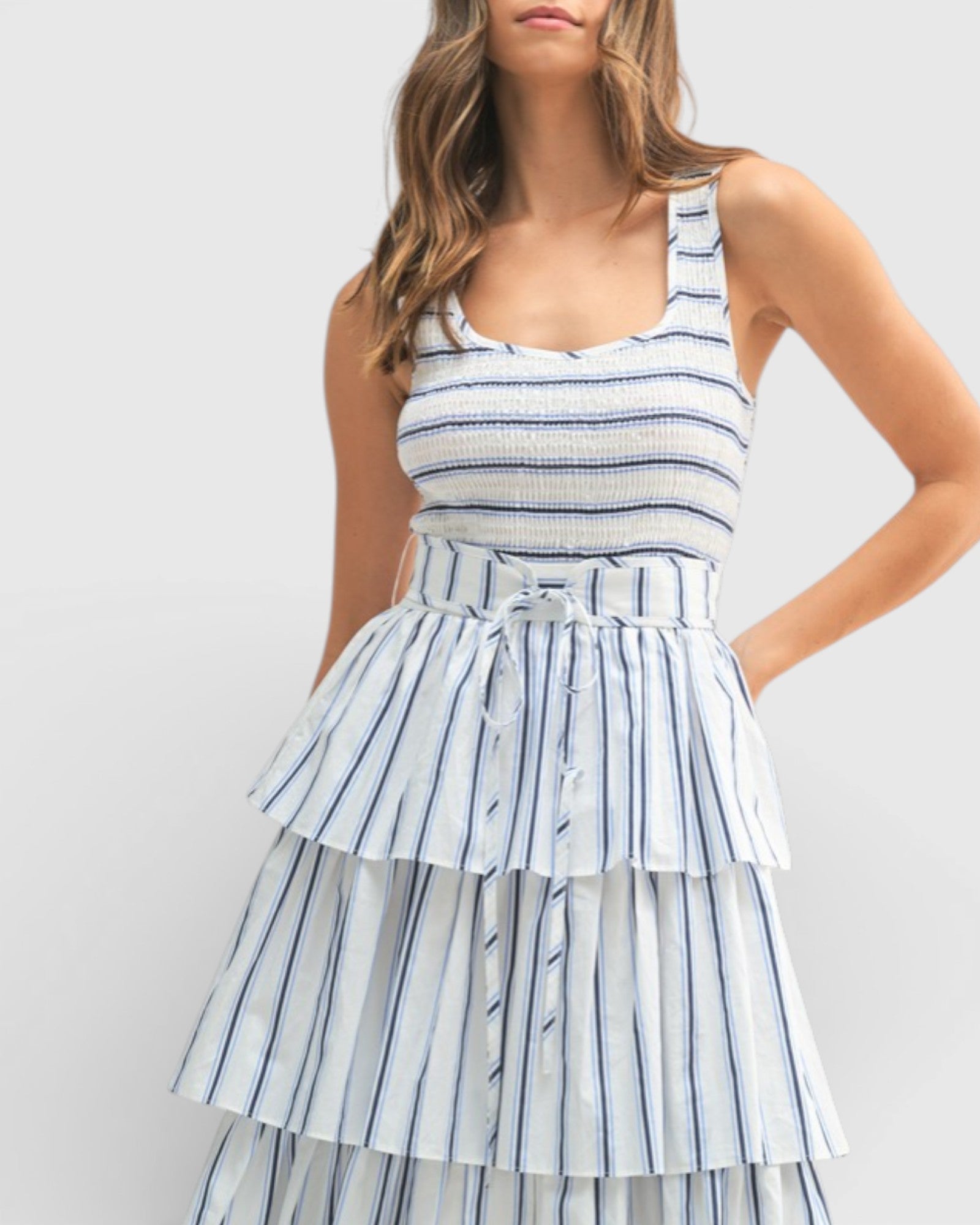 Woman wearing a blue and white striped dress on a plain background