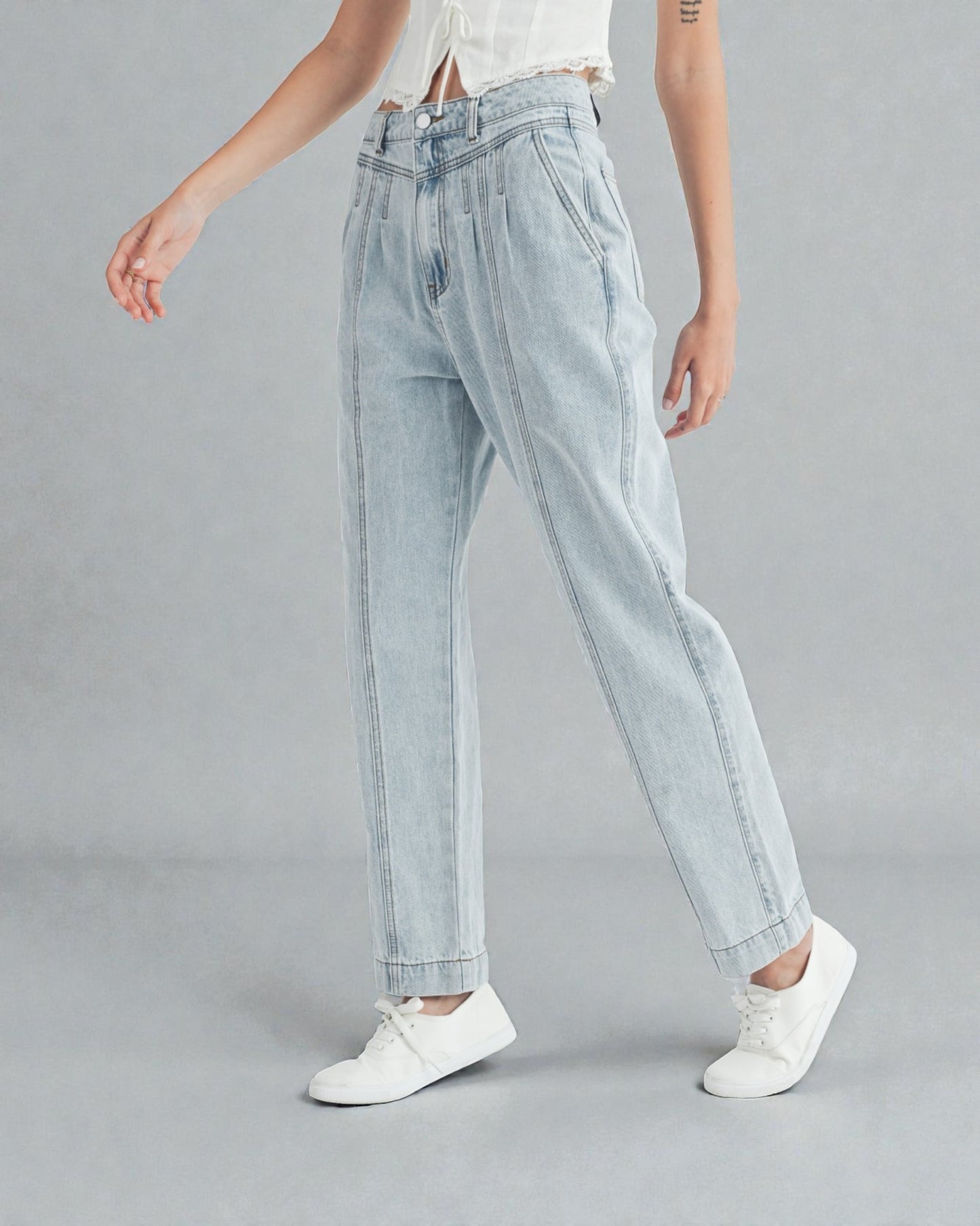 Light blue jeans worn by a person on a gray background