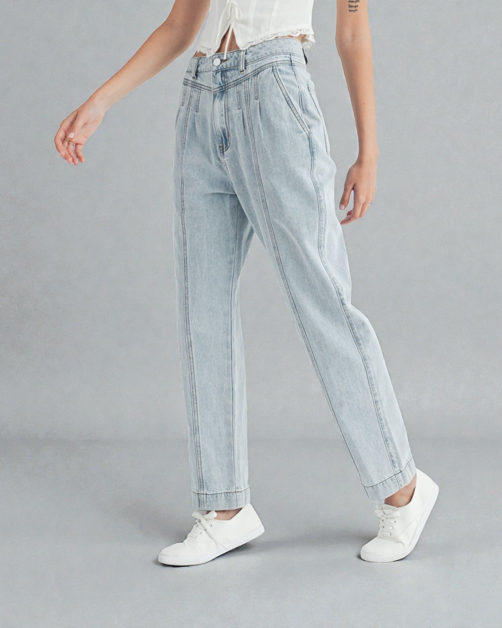 Light blue jeans worn by a person on a gray background