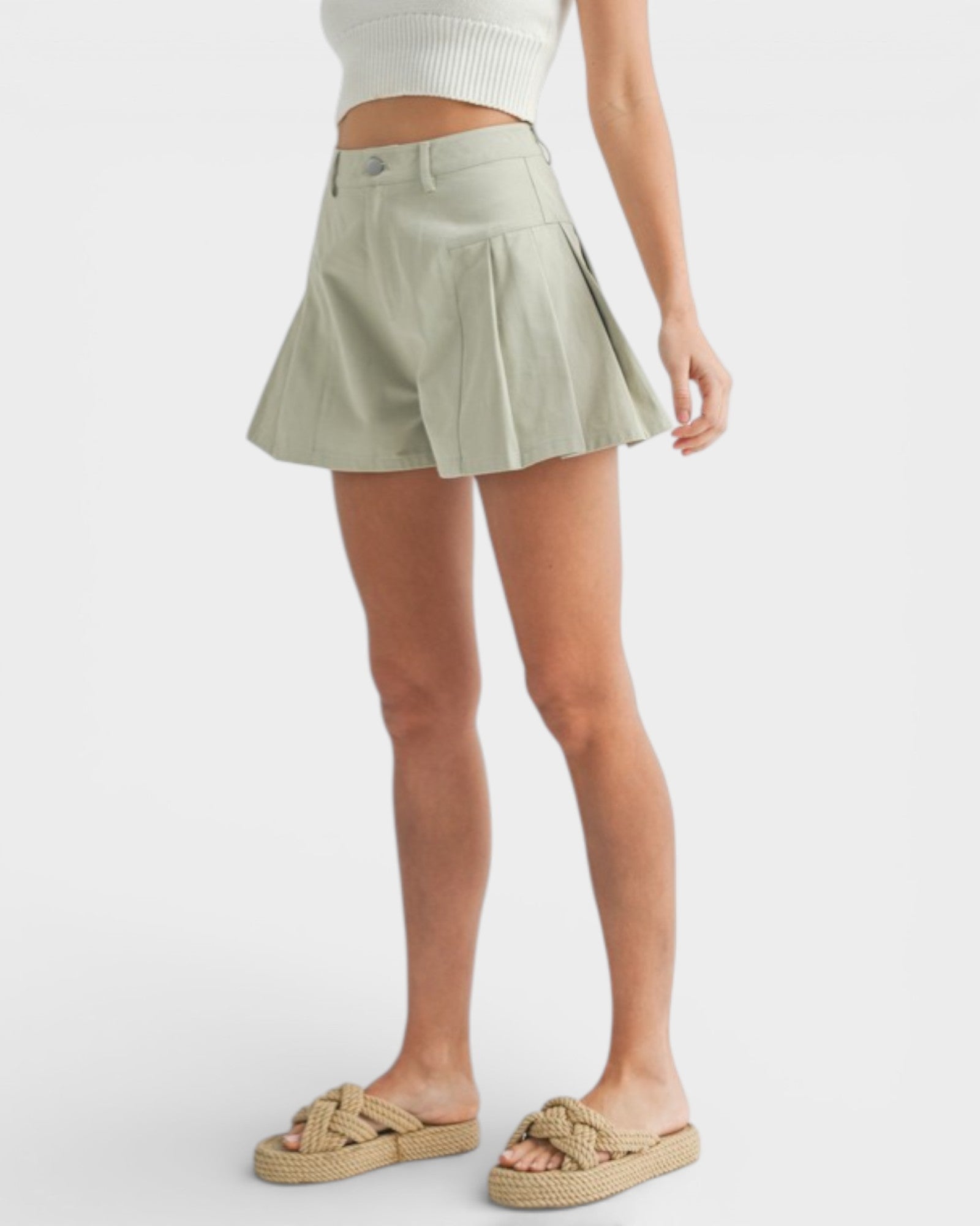 Person wearing a light green skirt on a white background