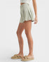 Person wearing a light green pleated skirt on a white background