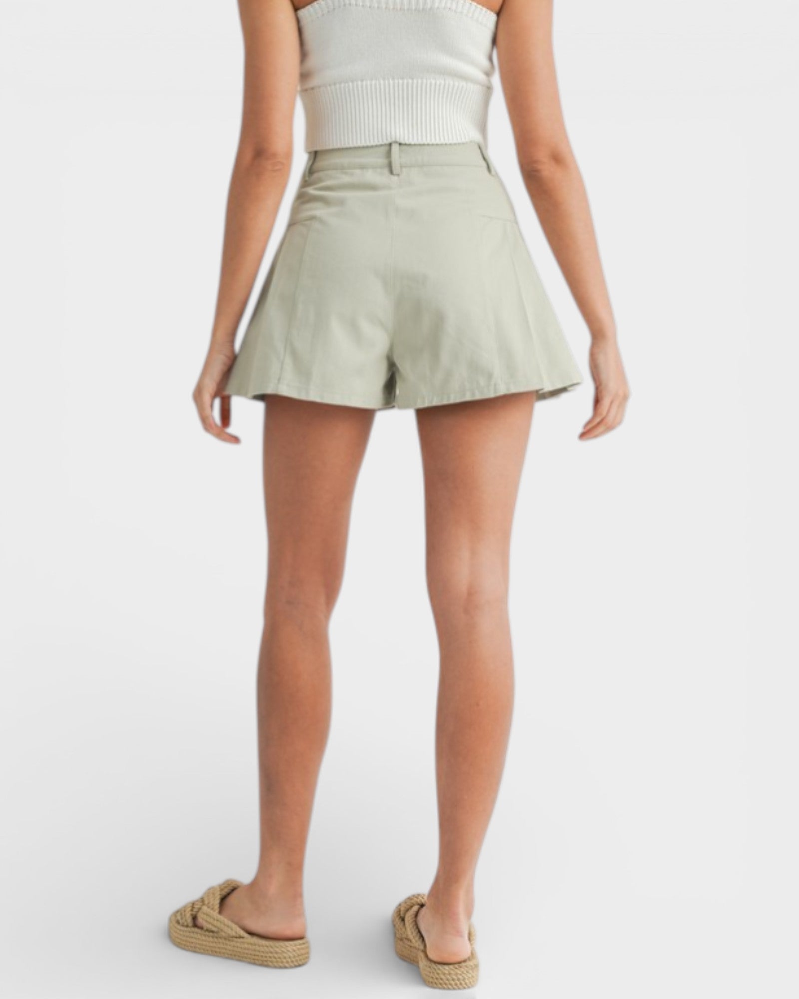 Person wearing light green shorts on a white background