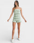 Woman wearing a light green strapless ruffled dress on a white background