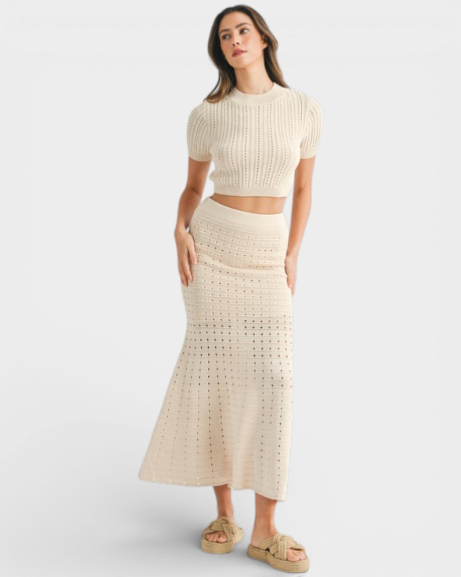 Woman wearing a beige knit top and skirt set on a white background