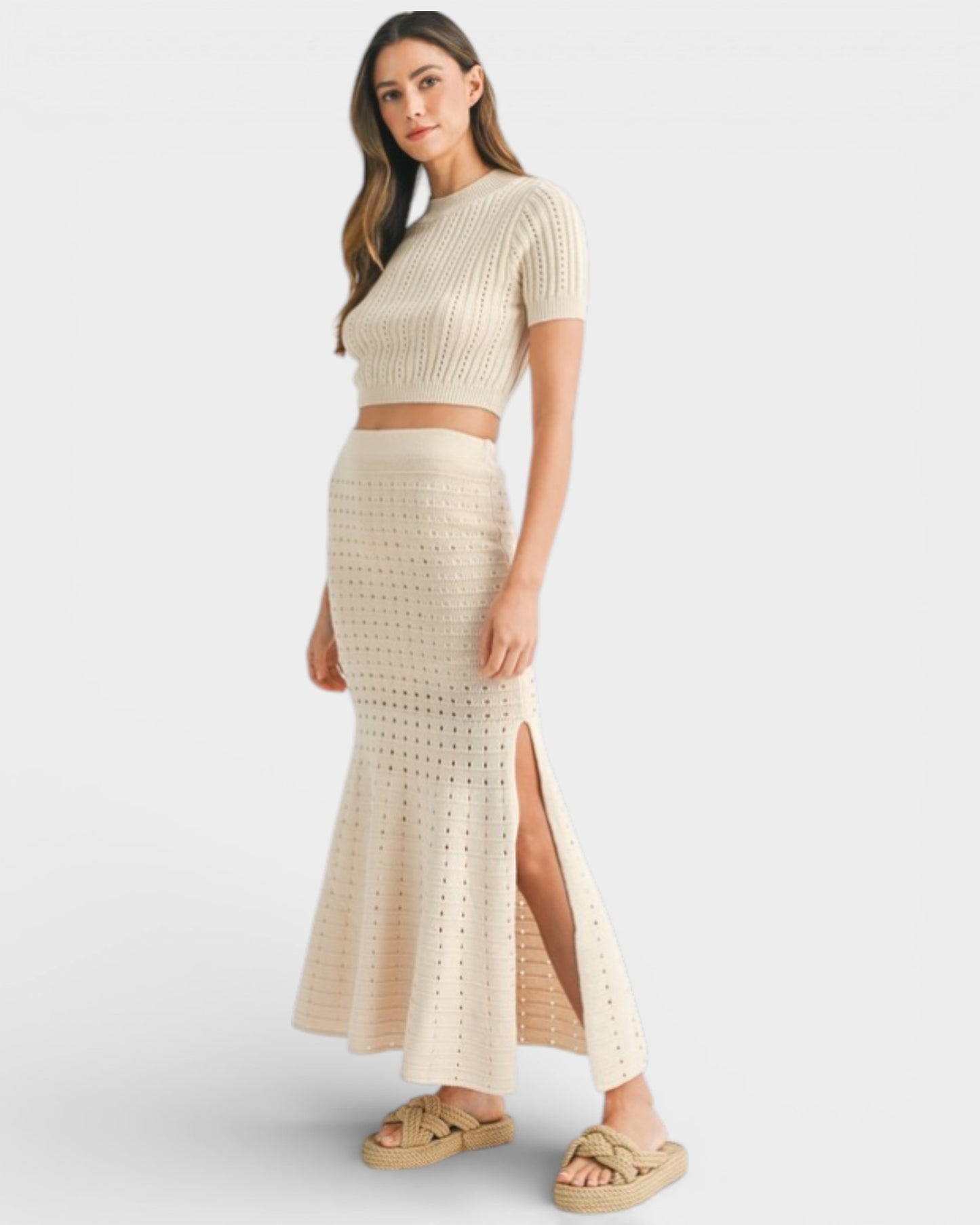 Woman wearing a beige knit two-piece set on a white background