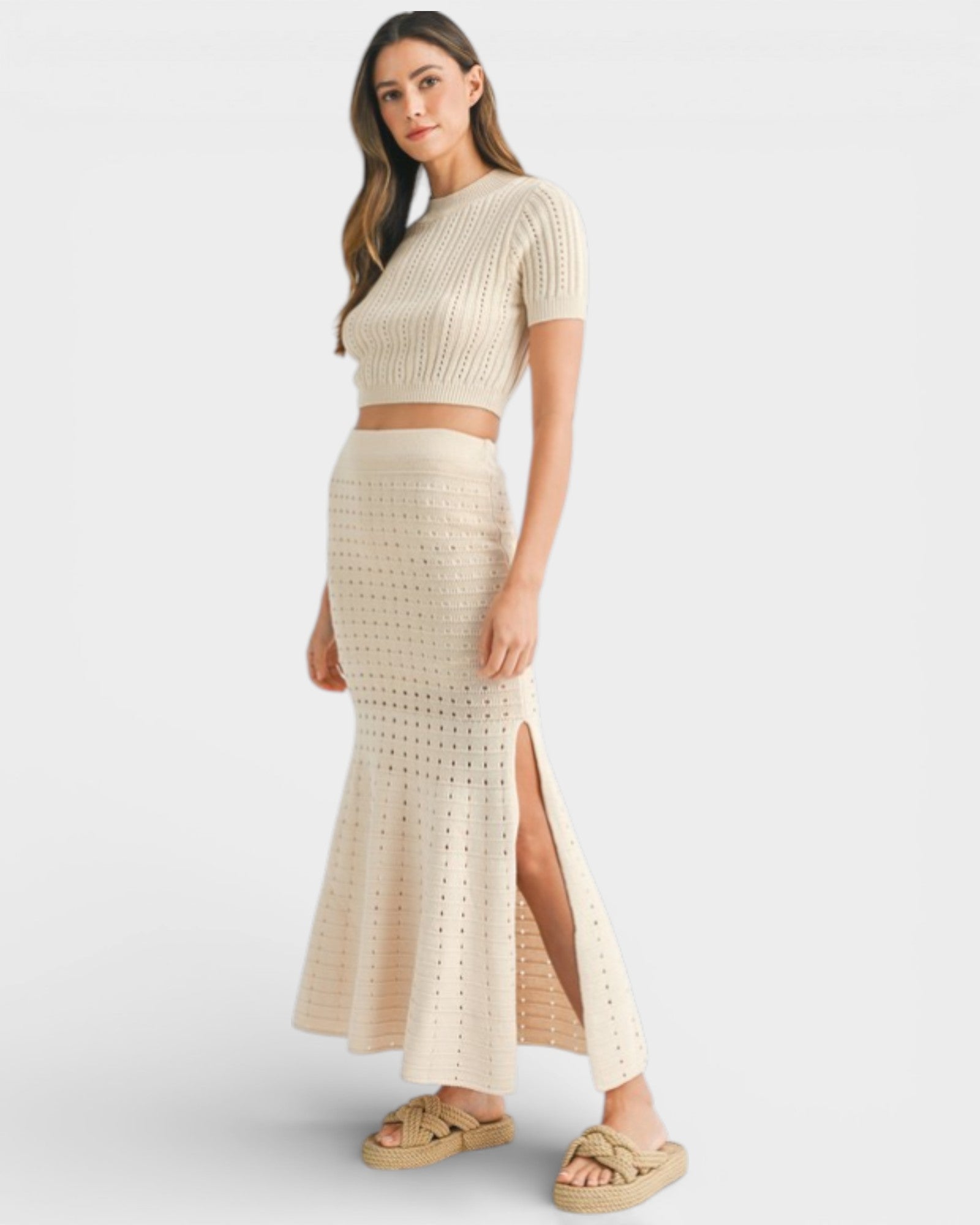 Woman wearing a beige knit two-piece set on a white background