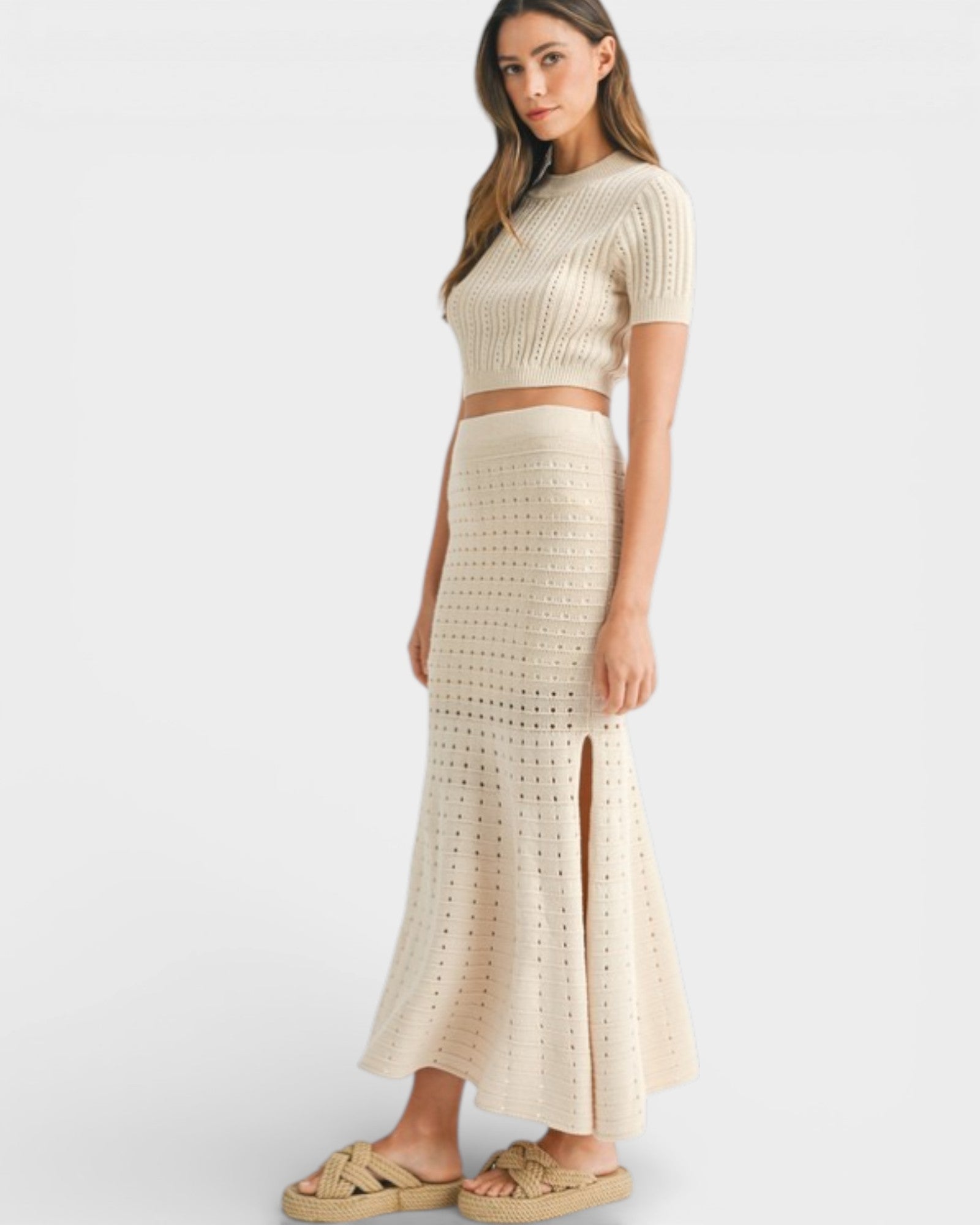 Woman wearing a beige knit two-piece set on a white background