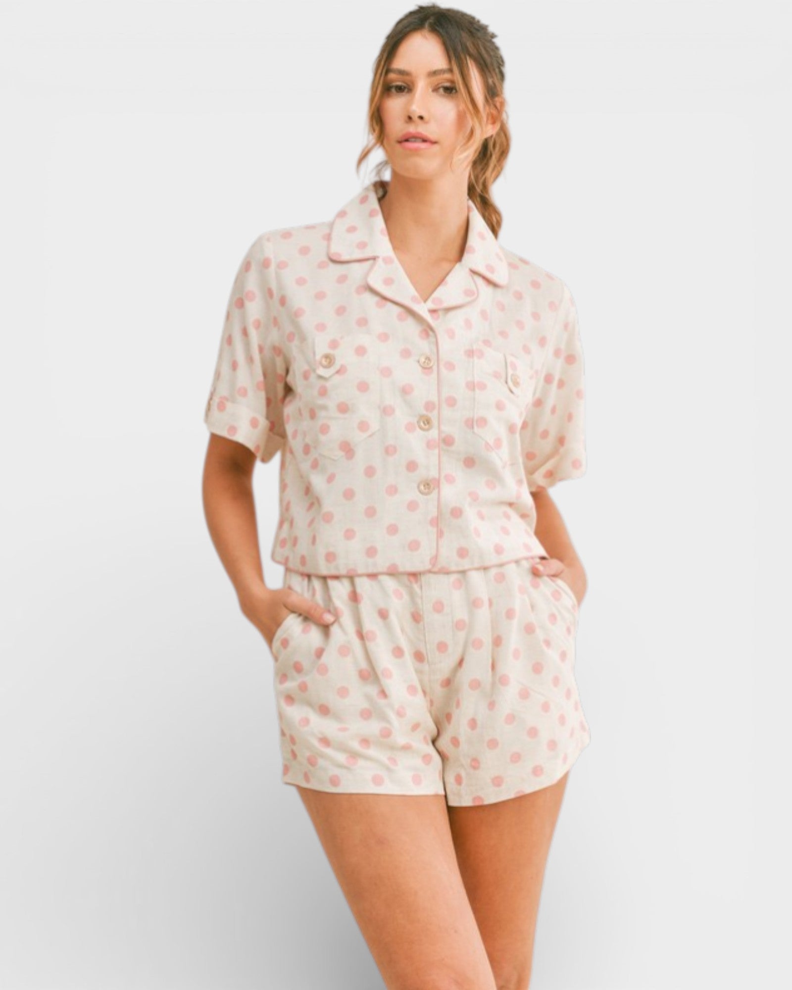 Woman wearing a light pink pajama set with a subtle pattern on a white background