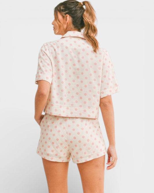 Woman wearing a polka dot pajama set on a white background