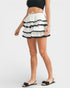 Woman wearing a black and white tiered skirt on a white background