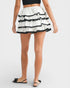 White skirt with black ruffles worn by a person on a white background