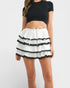 White skirt with black trim worn by a person on a white background