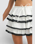 White shorts with black lace trim on a plain background