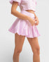 Person wearing a pink outfit with a skirt on a white background