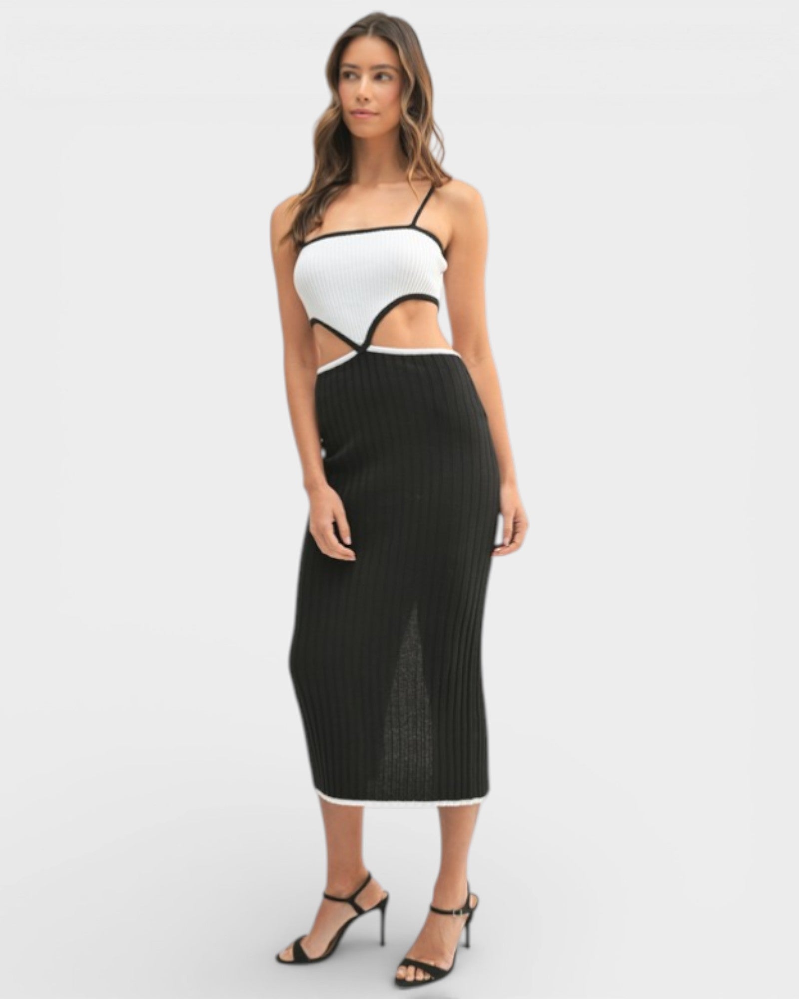 Woman wearing a white top and black ribbed skirt on a white background