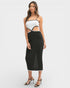 Woman wearing a white top and black ribbed skirt on a white background