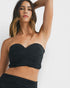 Woman wearing a black strapless top against a white background