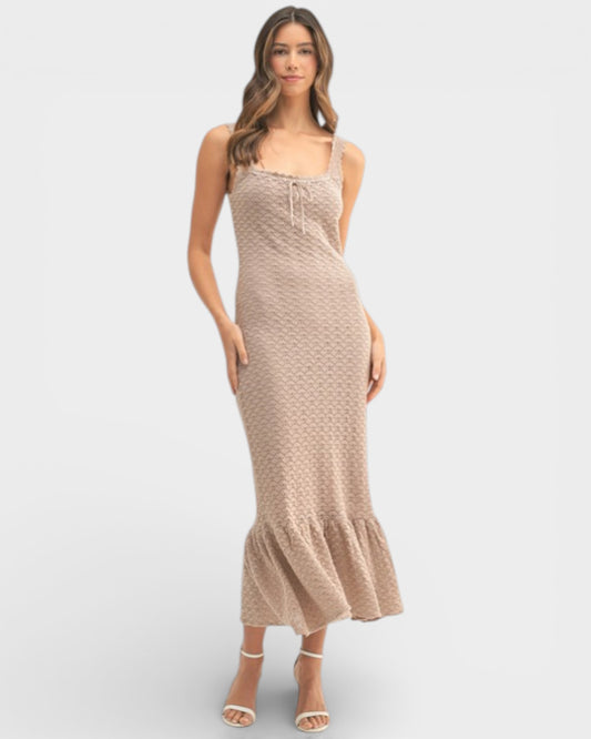 Woman wearing a beige patterned dress on a white background