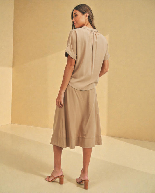 Woman wearing a beige dress against a beige background