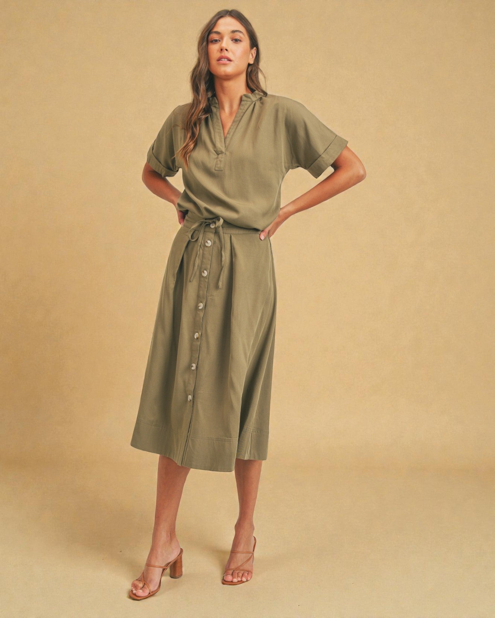 Woman wearing a green dress against a beige background