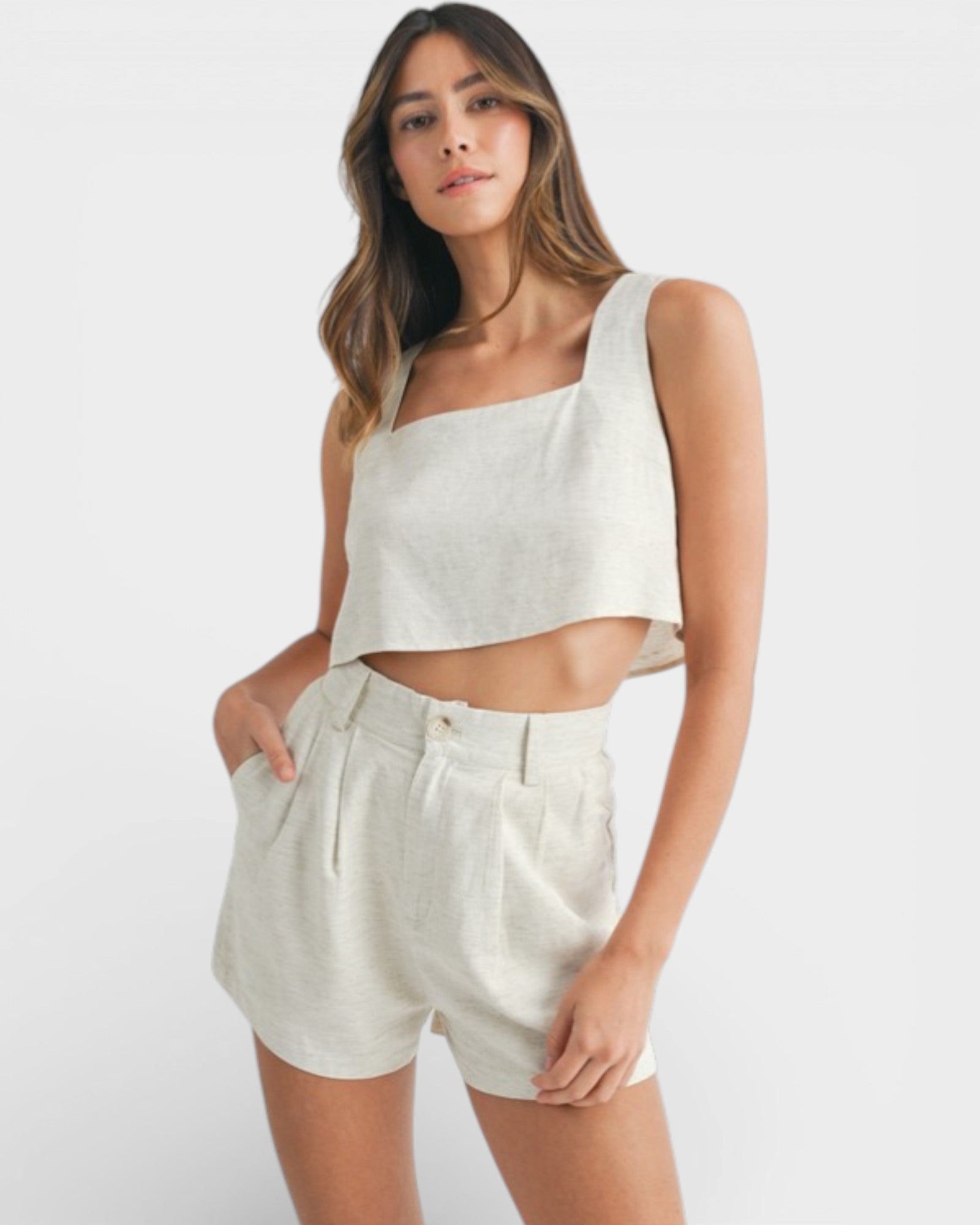 Woman wearing a white sleeveless top and shorts on a white background