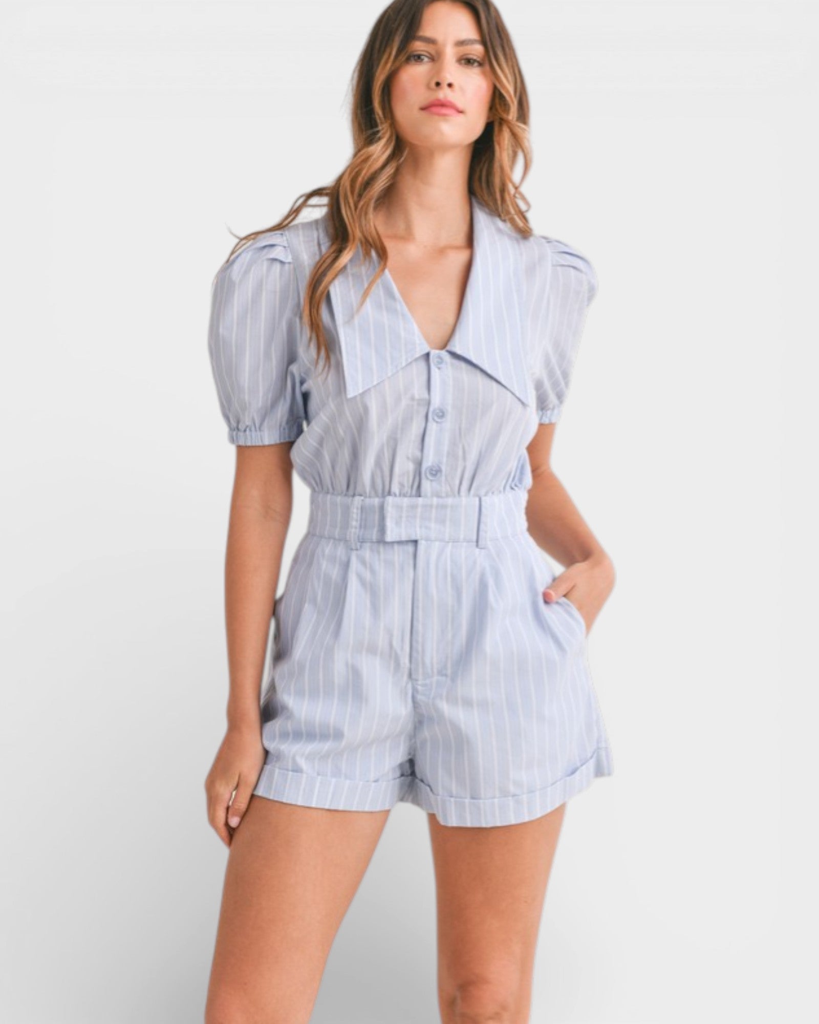 Woman wearing a blue and white striped romper on a white background