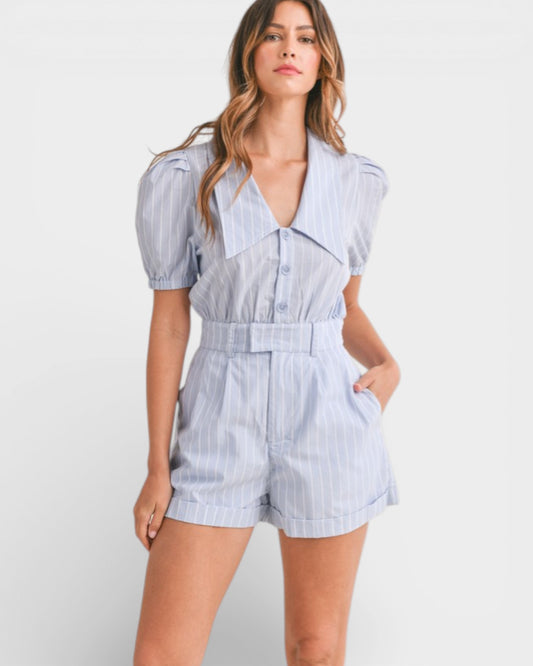 Woman wearing a blue and white striped romper on a white background
