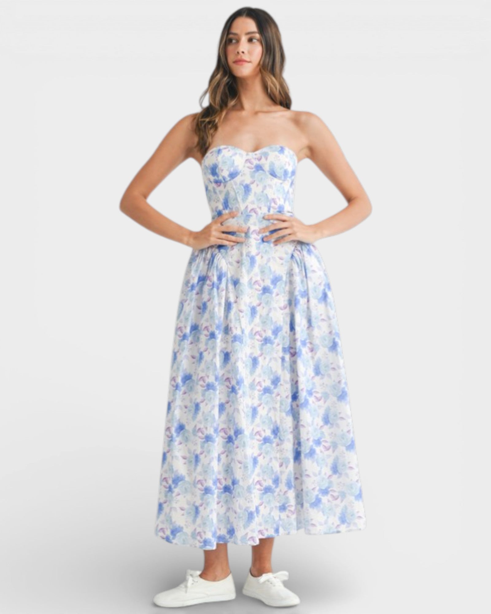 Woman wearing a strapless floral dress on a white background