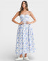 Woman wearing a strapless floral dress on a white background