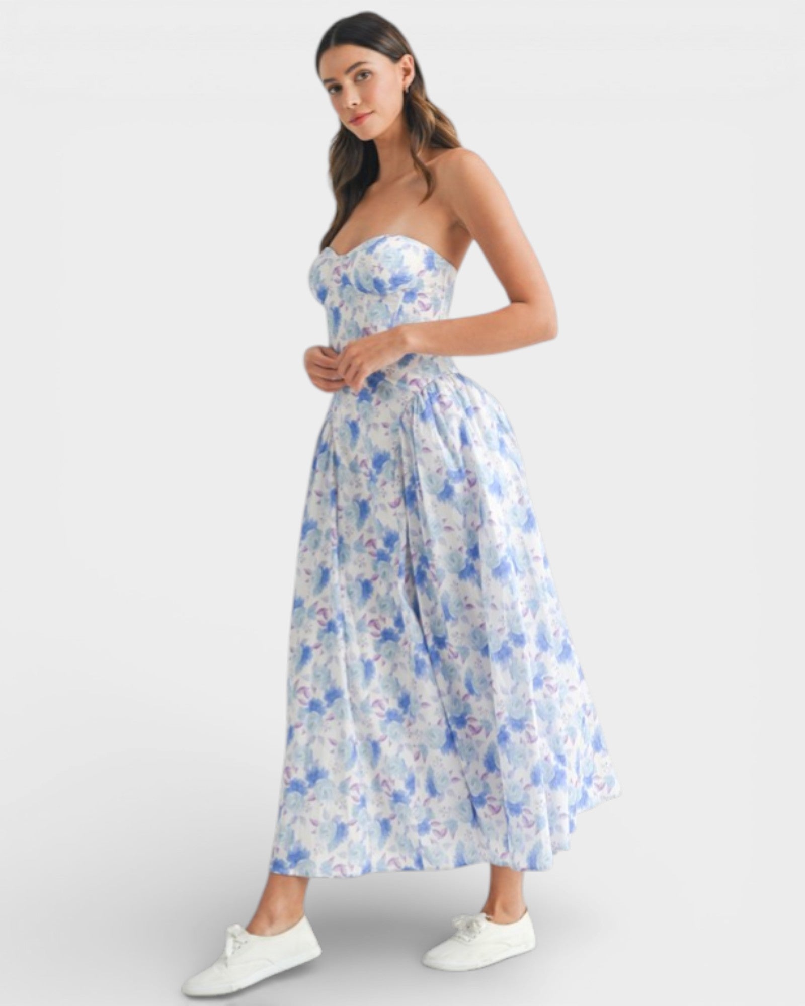 Woman wearing a strapless floral dress on a white background