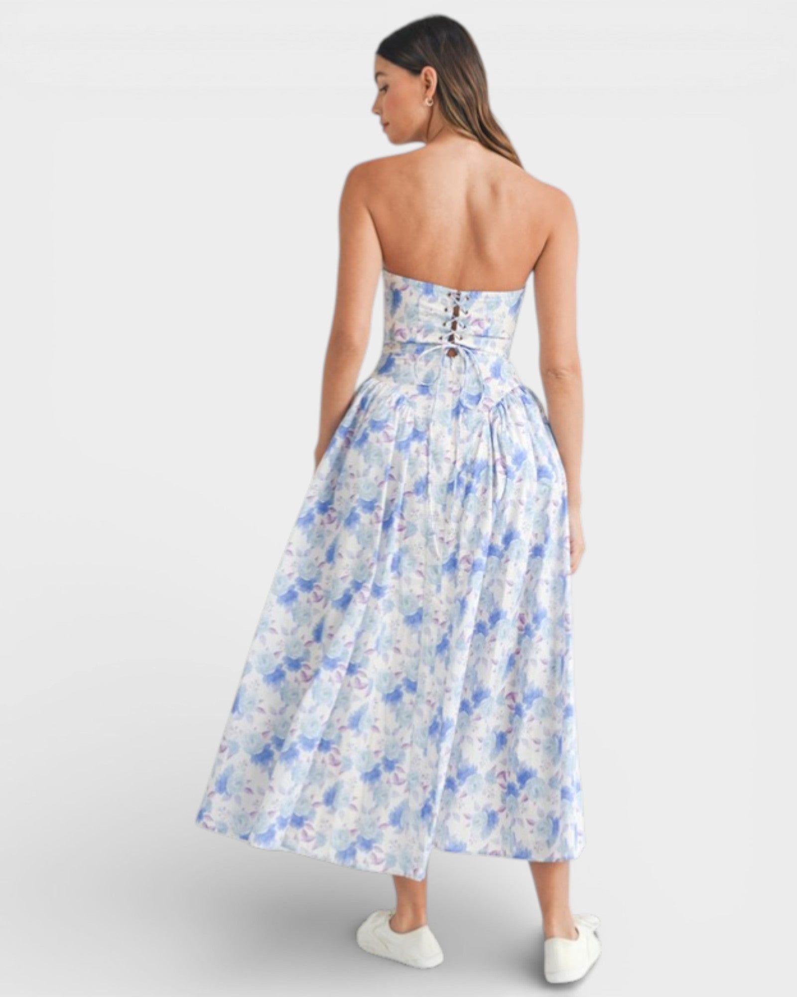 Woman wearing a strapless floral dress on a white background