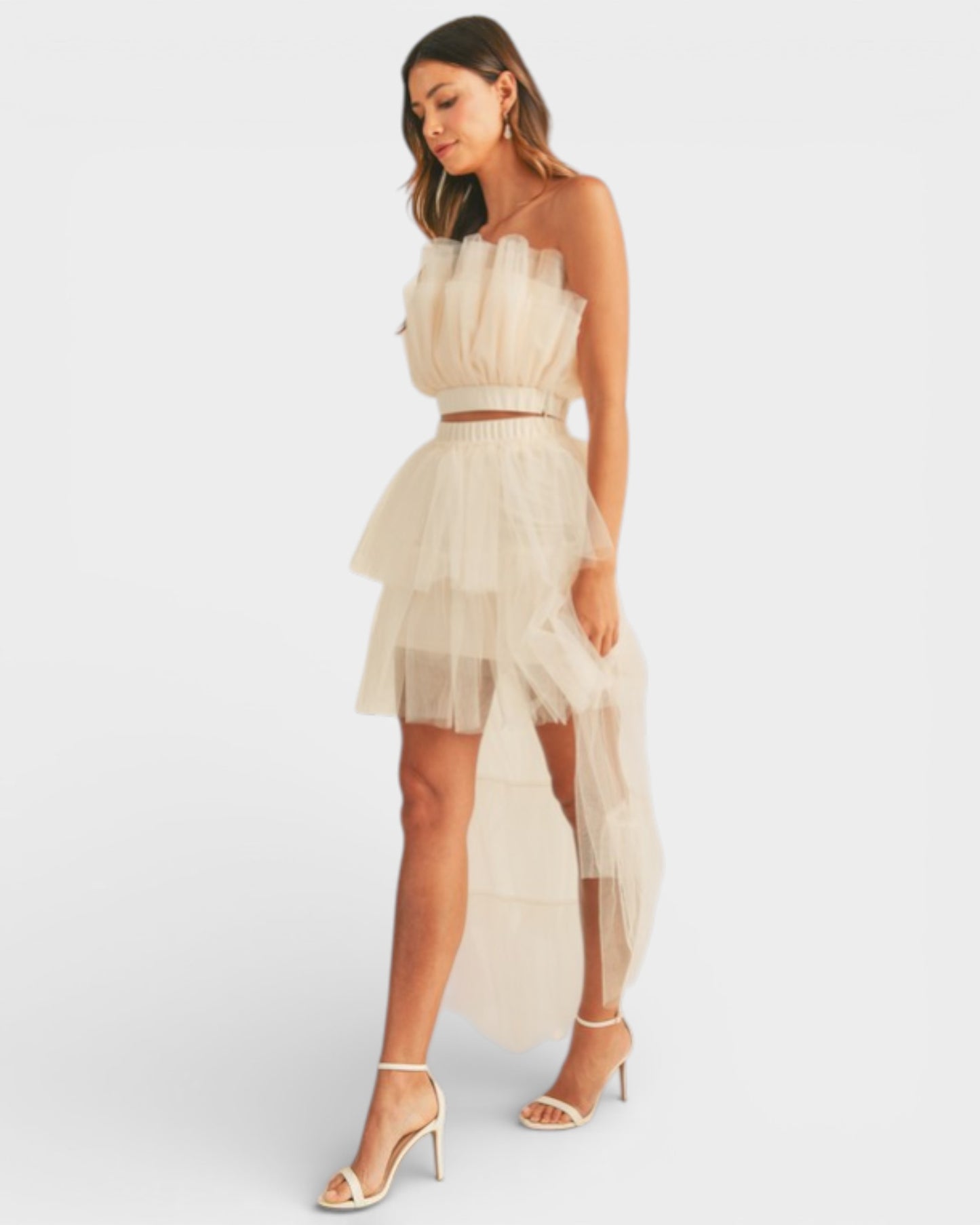 Woman wearing a beige strapless dress with a white background