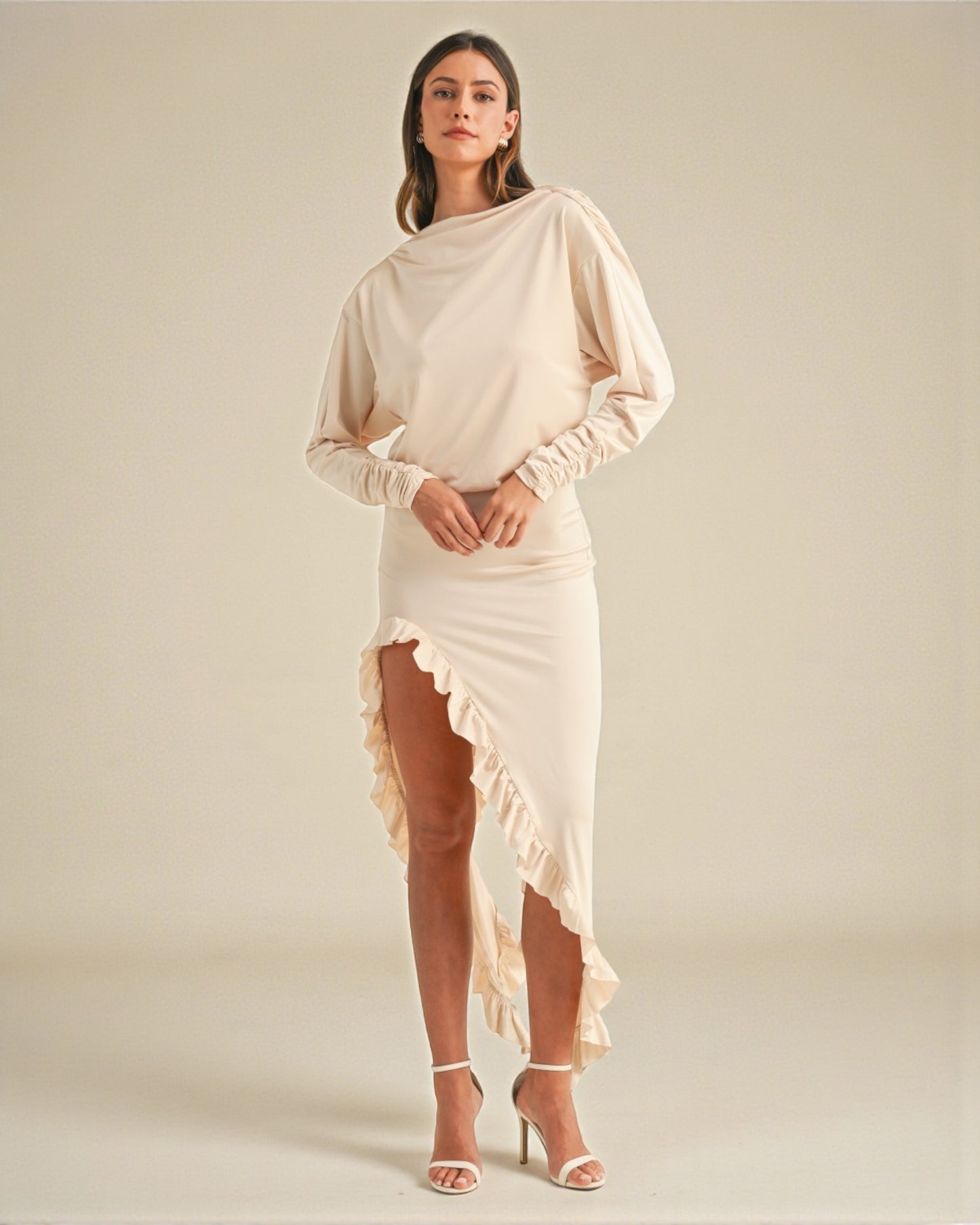 Woman wearing a beige dress with a plain background