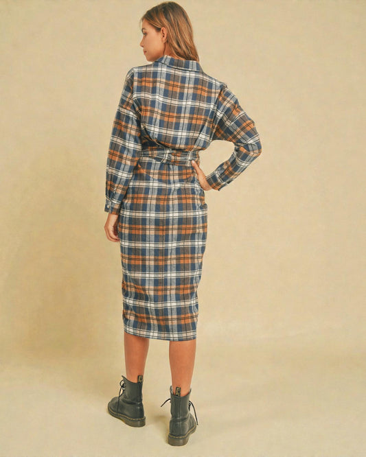 Woman wearing a plaid dress with a belt on a beige background