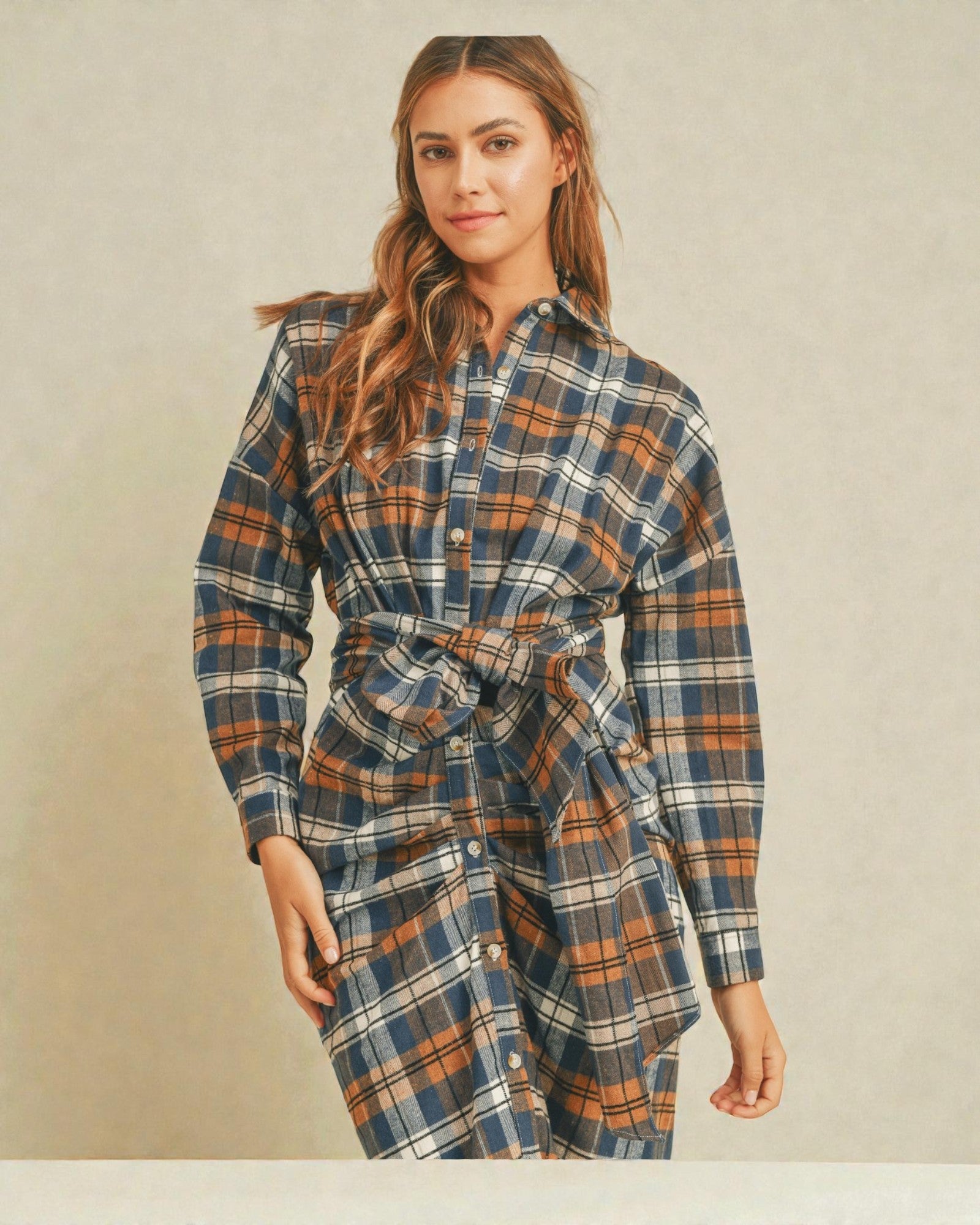 Woman wearing a plaid dress against a plain background