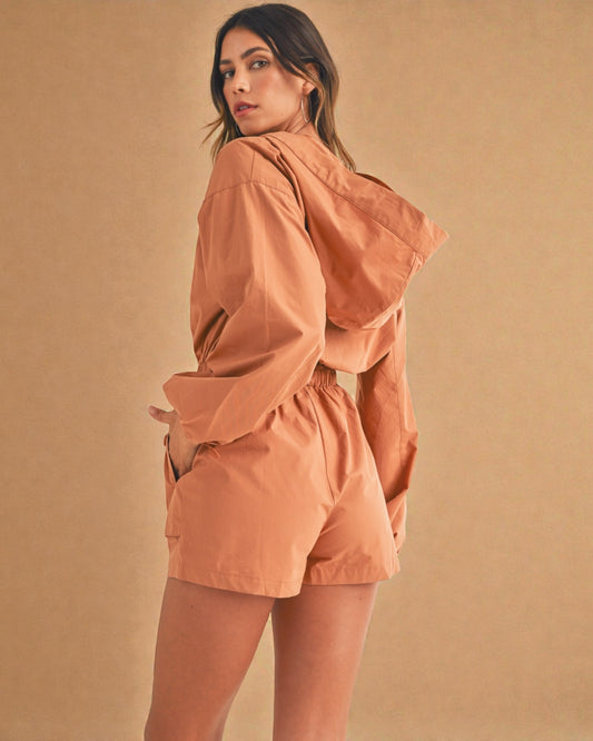 Woman wearing a peach-colored outfit against a matching background