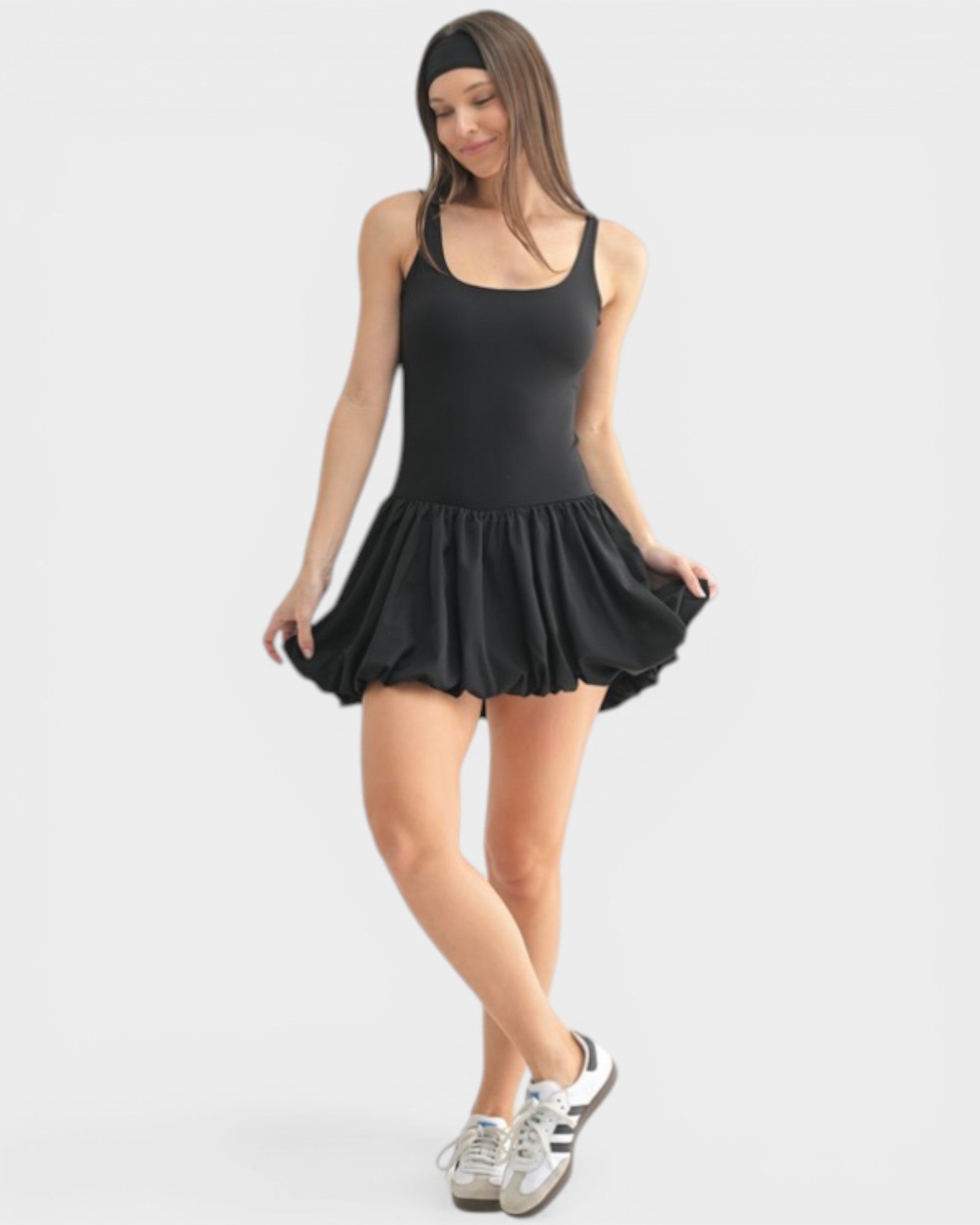 Woman wearing a black sleeveless dress on a white background