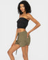Woman wearing a black strapless top and green shorts on a white background