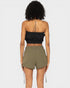 Person wearing a black strapless top and olive green shorts on a white background