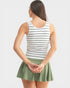Woman wearing a striped tank top and green skirt on a white background