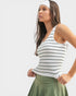 Woman wearing a striped tank top and green skirt on a white background