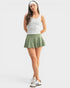 Woman wearing a striped tank top and green skirt on a white background